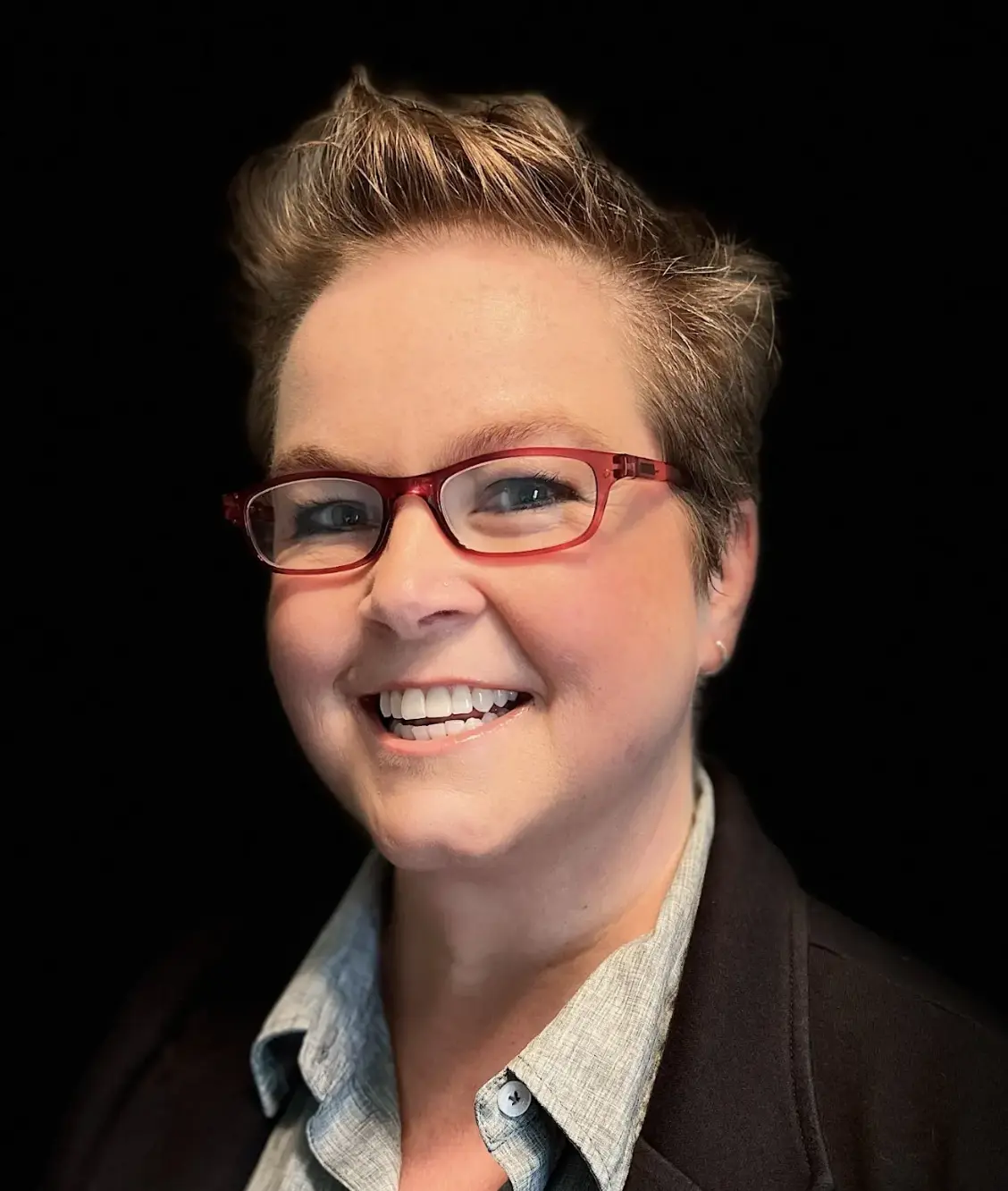 Headshot of Lyndee McNeese, Growth Director at eXp Realty, smiling and wearing red glasses and a collared shirt.