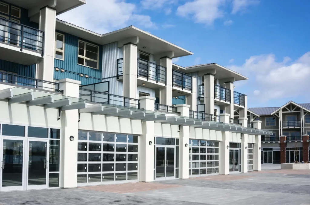 Modern mixed-use building with large glass storefronts on the ground level and residential units above.
